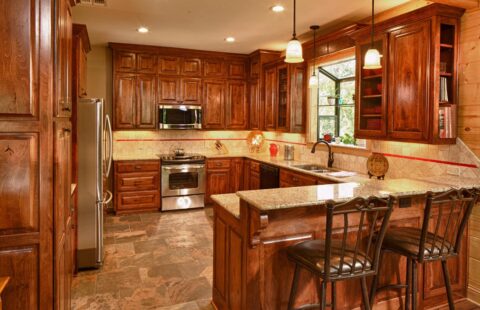 The image displays a beautifully designed kitchen, featuring our signature wooden cabinets harmoniously complementing granite counter tops.