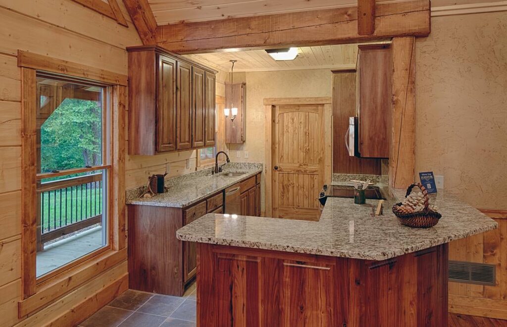 The image showcases a beautifully designed kitchen in one of our log homes, featuring robust granite countertops.