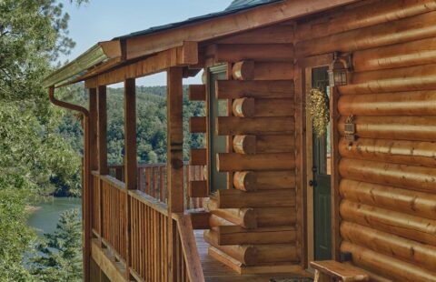 The image features a beautifully crafted log cabin boasting a charming balcony with stunning views overlooking a serene lake.
