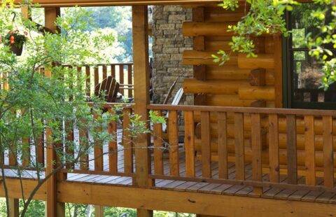 The image depicts a charming, expertly crafted wooden deck complete with a sturdy, intricately designed wooden railing.