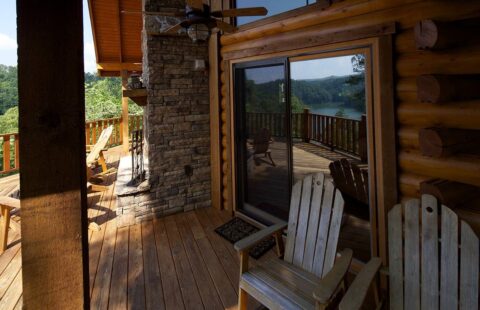 Our log home features a charming wooden deck, perfectly outfitted with two inviting Adirondack chairs.