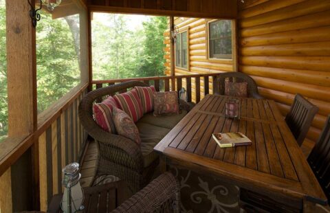 The image showcases some beautifully crafted wicker furniture placed on the porch of one of our meticulously built log cabins.