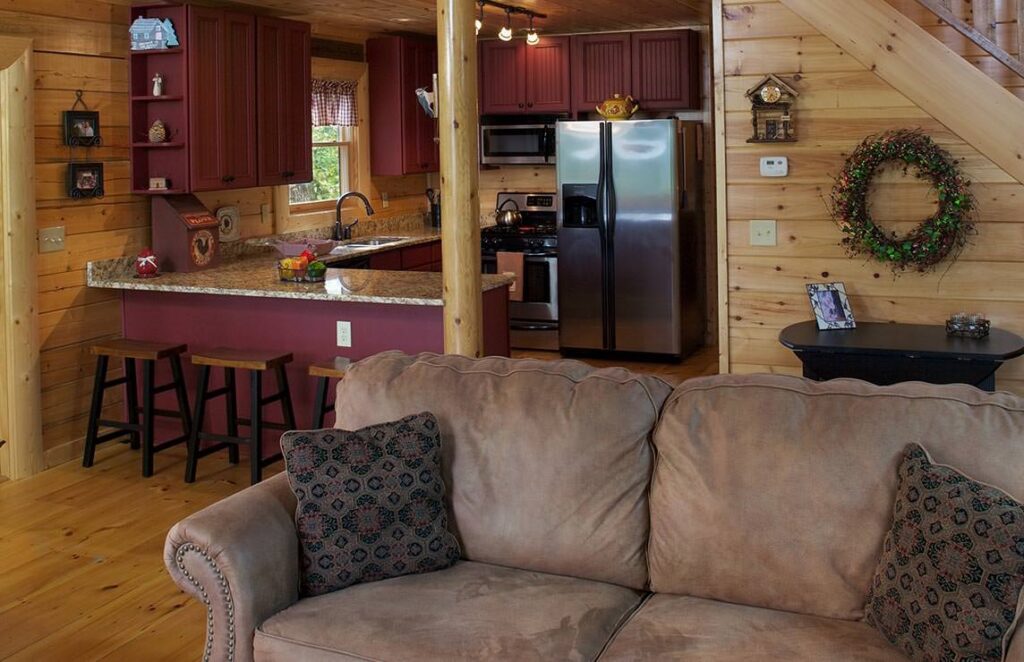 The image showcases a cozy and inviting living room in one of our beautifully crafted log cabins, featuring rustic furnishings and warm ambient lighting.