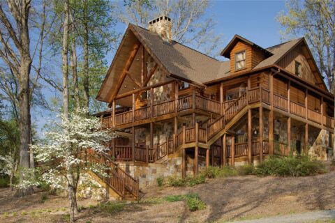 The image showcases a spacious and beautifully crafted log cabin nestled amidst the tranquility of dense, verdant woods.