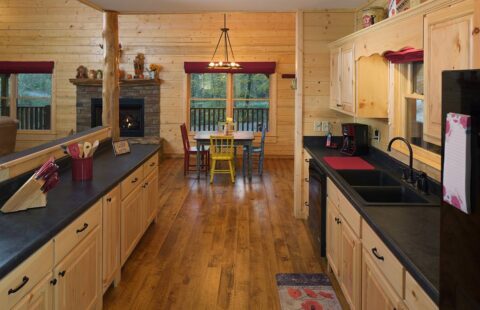 The image showcases a warmly inviting, rustic-style kitchen nestled within one of our expertly crafted log homes.
