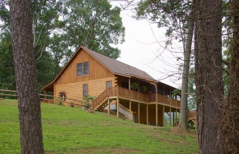 Our company's sturdy, beautifully designed log home majestically stands atop a hill.