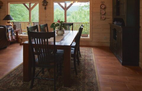 The image showcases a rustic yet elegant dining room, resplendently fashioned in the interior of one of our beautifully crafted log cabins.
