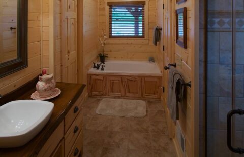 The image showcases a rustic, cozy bathroom inside one of our meticulously crafted log cabins.