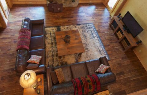 The image showcases a bird's eye view of a spacious and inviting living room within one of our beautifully constructed log cabins.
