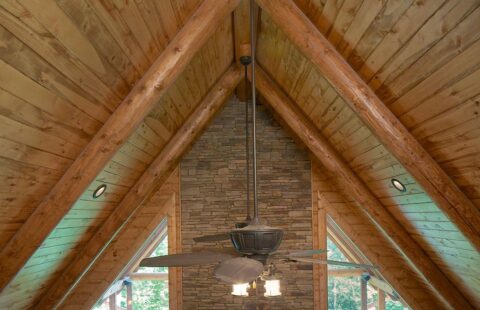 The image showcases a ceiling fan immaculately installed, providing a modern touch to the rustic charm of our log cabin.