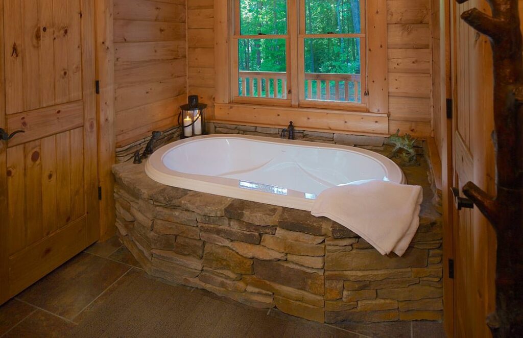 The image showcases a luxurious bathtub set within the rustic charm of one of our meticulously crafted log homes.