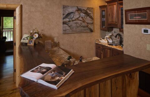 The image displays a rustic wooden bar, elegically complemented by a solitary book.