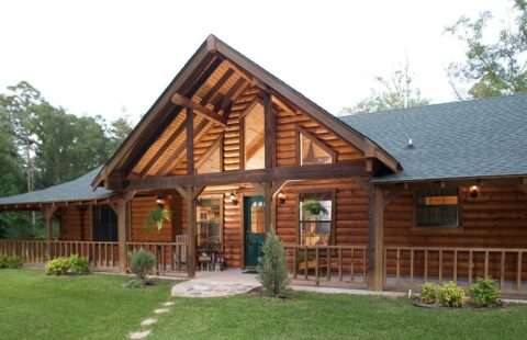 The image showcases a beautifully built log home complemented with an inviting porch along with multiple other porches adding to its rustic charm.