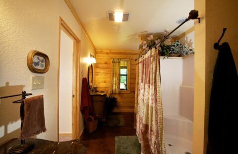 The image displays a beautifully designed bathroom in one of our expertly crafted log cabin homes.