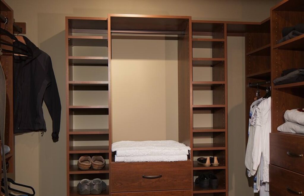 The image showcases a spacious walk-in closet, outfitted with beautifully crafted wooden shelves and drawers, embodying our expertise in using wood for functional and aesthetic purposes.