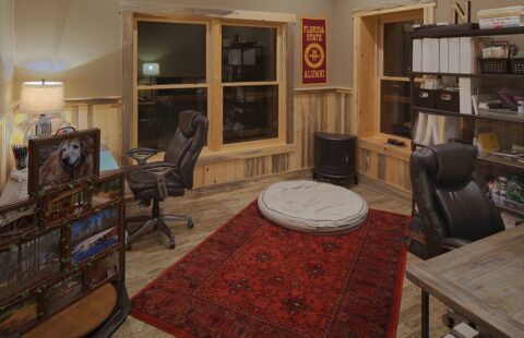 The image showcases a beautifully designed room in one of our log homes, featuring an elegant desk and a cozy rug.