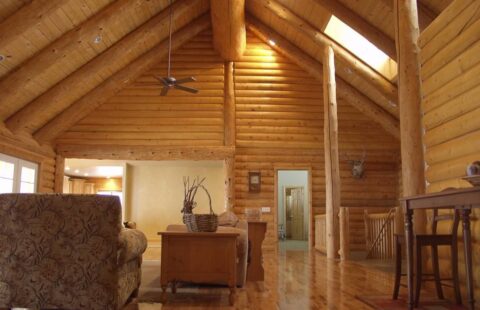 The image showcases a cozy and rustic living room situated in one of our beautifully crafted log cabins.