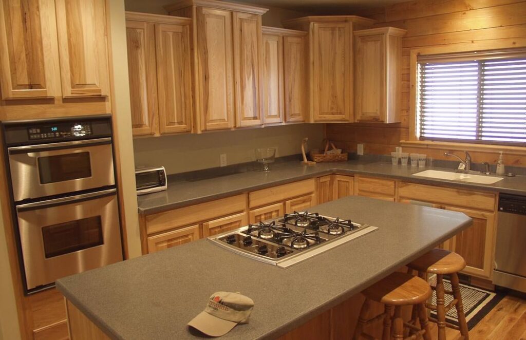The image showcases a beautifully designed kitchen featuring our signature wood cabinets and the sleek sophistication of stainless steel appliances.