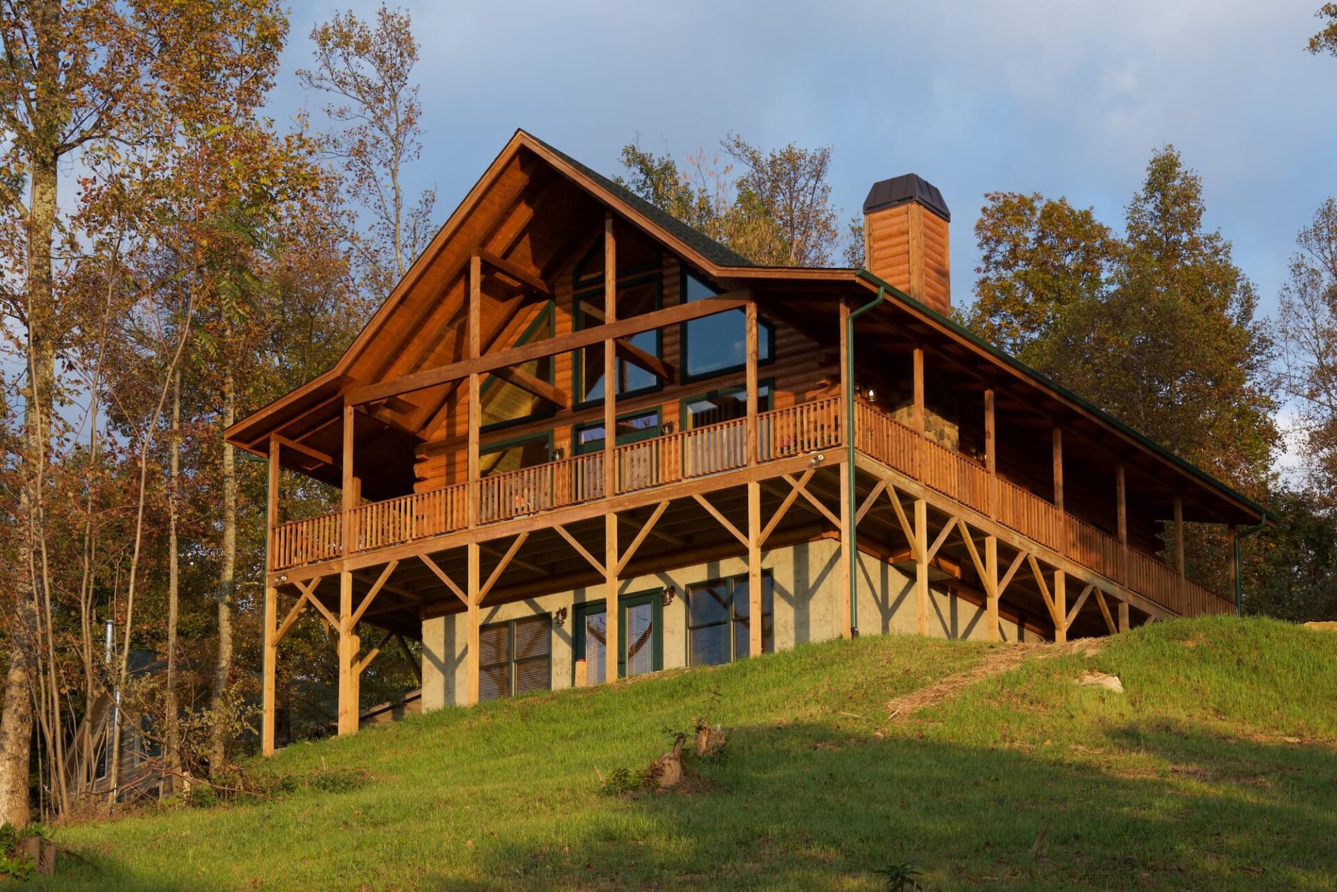 Our company crafts beautifully designed log homes, like this one nestled serenely on a picturesque hill.