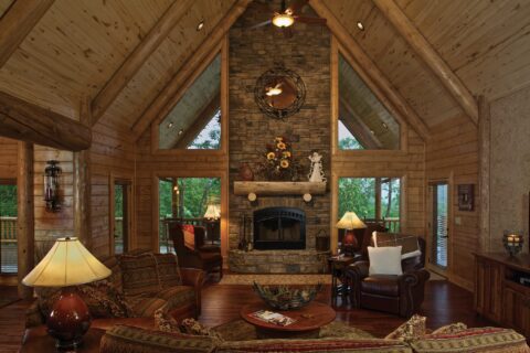 The image displays a cozy fireplace in the living room of one of our beautifully crafted log homes.