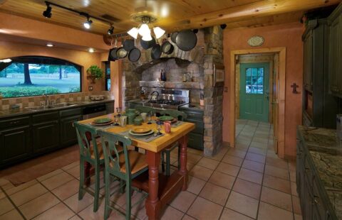 The image showcases a beautifully crafted kitchen within our log cabin, complete with a rustic dining table and chairs.