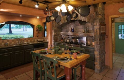 The image showcases a rustic kitchen in one of our log homes where pots and pans are neatly arranged on the counter.