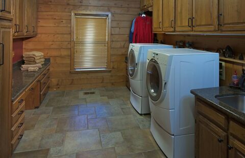 The image showcases a laundry room within our log home, equipped with modern washer and dryer set.