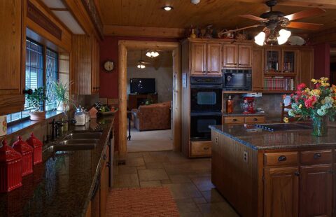 Our log home features a stunning kitchen complete with rich wooden cabinets and a polished granite counter top.