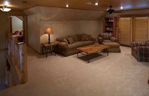 Our log homes feature a cozy living room complete with comfy couches and a warm, inviting fireplace.