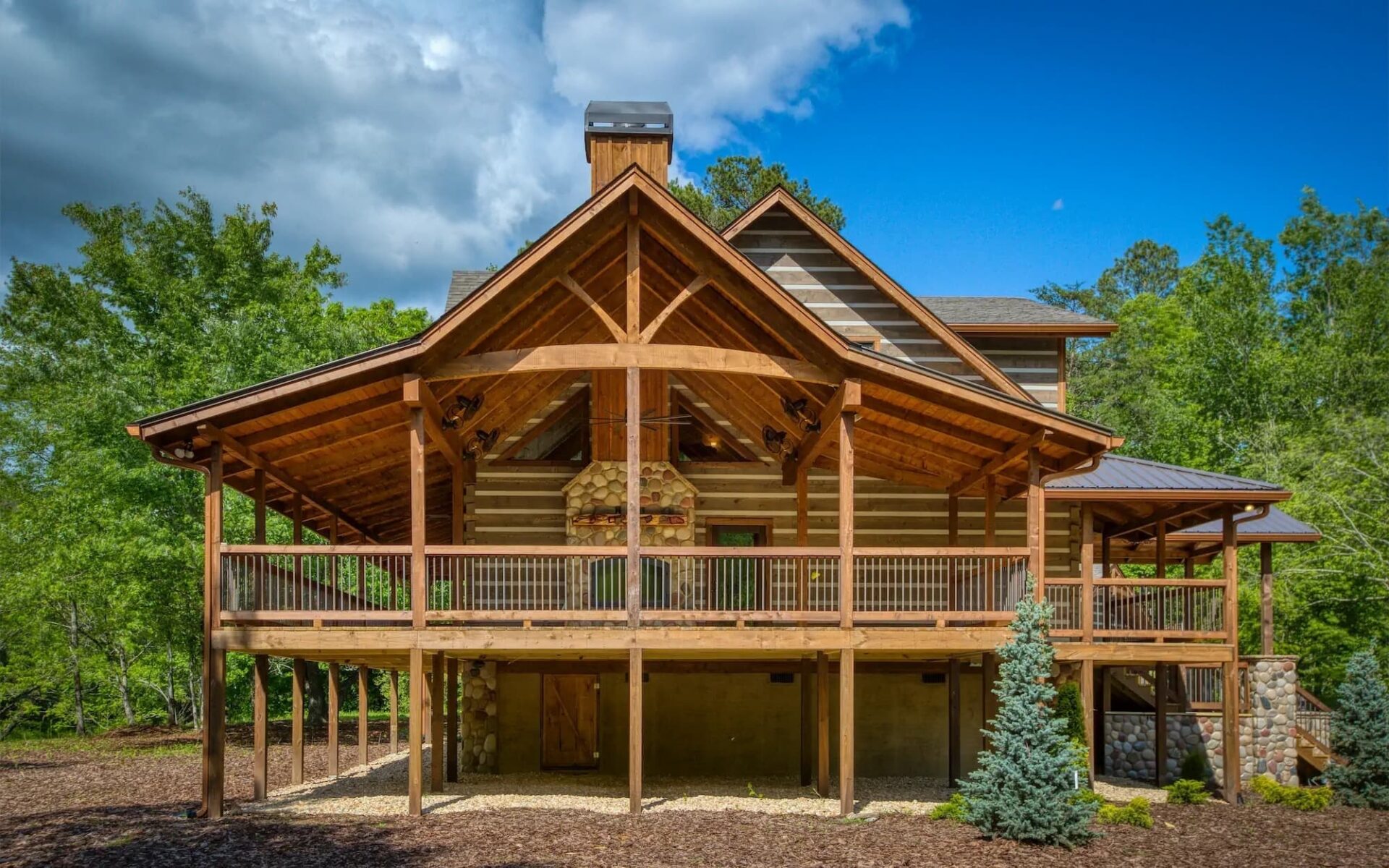 Our product image displays a stunning log home nestled amidst lush woods, boasting of a spacious deck and inviting porch.