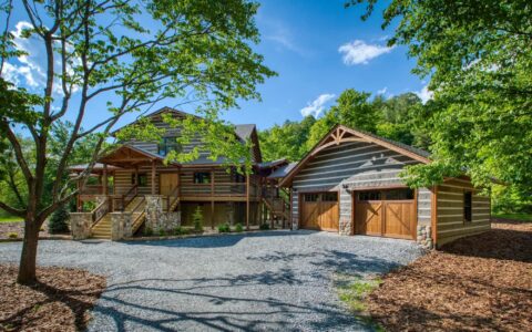 The image illustrates one of our beautifully crafted log homes, nestled in the serenity of a verdant forest complemented with a convenient driveway.